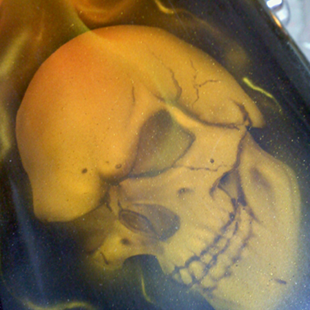 custom painted motorcycle gas tank with airbrushed skulls and flames